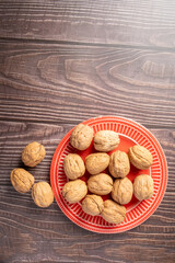 Walnuts, walnuts in their shells, and accessories positioned on a dark rustic table, Top view.