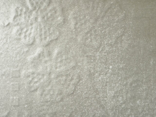 Obraz premium Textured snowflake pattern on light gray surface with subtle shadows