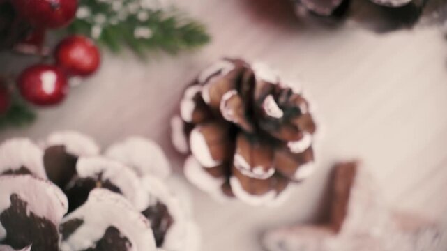 Top-view camera moves upward across Christmas table decorations, revealing pinecones and festive elements in a warm holiday flat lay