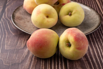 Peaches, beautiful peaches in a porcelain dish positioned on a rustic table, Selective Focus.