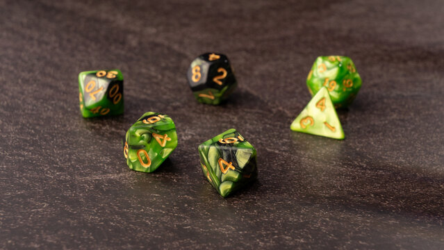 RPG dice rolled randomly on a dark surface and dark background, Selective Focus.
