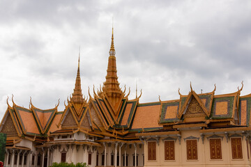 Fototapeta premium Extensive and ornate roofline of the Silver Pagoda stretches across the frame, showcasing intricate gables and golden spires of traditional Khmer architecture at Royal Palace in Phnom Penh, Cambodia