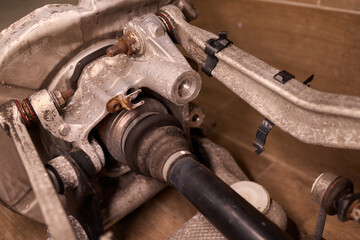 Vintage vehicle restoration, Old car parts under warm workshop lighting, Scene depicting classic vehicle undergoing restoration with rusted parts and scattered tools