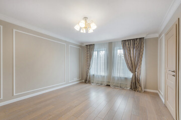A spacious empty room with a window and a door. The final finishing of the walls and floor. Unfurnished.