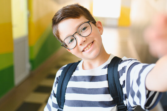 Smiling student taking selfie in school hallway