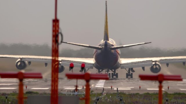 A huge wide-body four-engine airliner on the runway, rear view. Concept aviation, flight, tourism, cargo transportation, travel