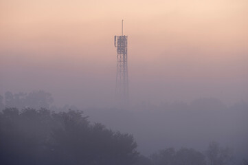 朝靄が漂う淡い空に浮かぶ電波塔