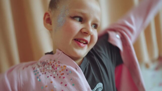 A little girl puts on a sweater, the child dresses on his own