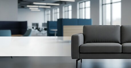 A modern office space featuring a comfortable gray sofa in the foreground, creating a welcoming and professional atmosphere for collaboration