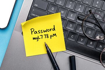 Password sticky note on office laptop keyboard