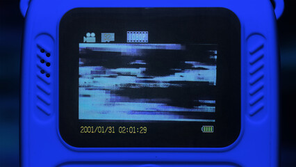 digital camera display showing a distorted video feed with heavy glitch artifacts. The screen...