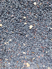 Pile of small stones. Natural rough Texture. Gray-black decorative Pebbles. Crushed Rock. Rocky garden path. Gravel ground. Landscaping material, outdoor background. Construction base. Vertical photo