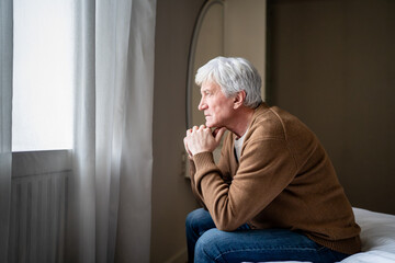 Older man sitting alone in emotional burden mental fatigue and deep depression. Elderly male...