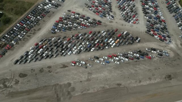 Large collection of parked cars in a vast lot near a construction site at Copart yard, York, North Yorkshire.