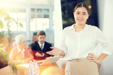 Young woman in business clothes posing during meeting in office..