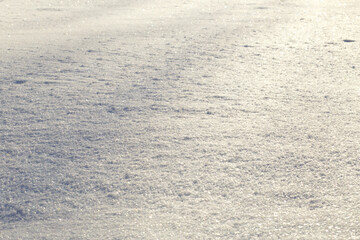 Snow surface sparkling in sunlight. Natural white winter texture background, cold season and holiday concept.