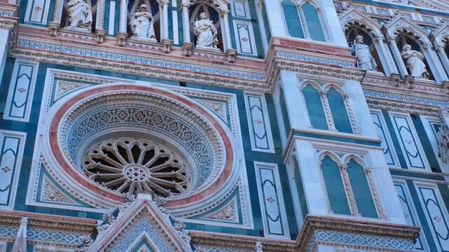 Florence cathedral facade: exploring architectural details. Polychrome marble panels and intricate carvings adorn the facade of florence cathedral, showcasing gothic architecture