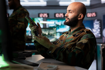 Infantry unit in command post putting ammunition in pistol cartridge, preparing to attack enemy forces. Middle Eastern army soldier reloading handgun, preparing to start assault mission