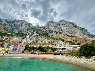Catalan Bay: view of the bay and fishing village with beach in Gibraltar at a slightly cloudy summer day, Rock of Gibraltar, Strait of Gibraltar, Mediterranean Sea, British Overseas Territory, Europe