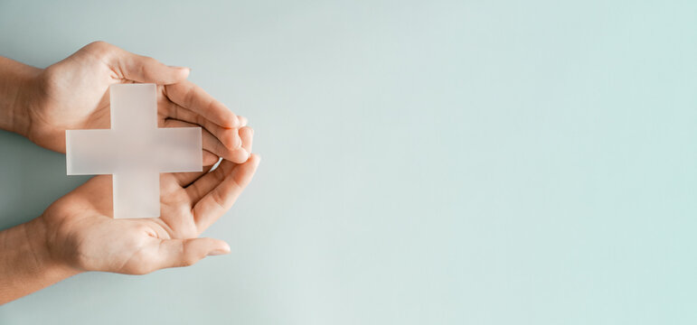 Hands holding Plus cross  on blue background, medical healthcare, first aid, mental health, wellness support, positivity concept