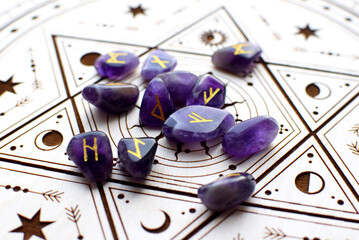 Scandinavian runes made of natural amethyst on a wooden altar for divination. Fortune telling, witchcraft, and spiritual esoteric practice.