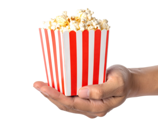 Hand holding delicious striped popcorn bucket, perfect for movie nights and parties