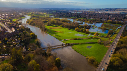 Aerial shot showing river and autumn flooding near urban area