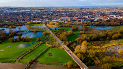 Wet autumn fields and highway crossing the river flood
