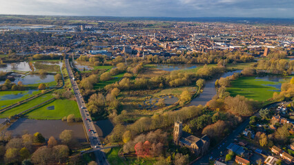 Autumn river plains and highway leading into urban area