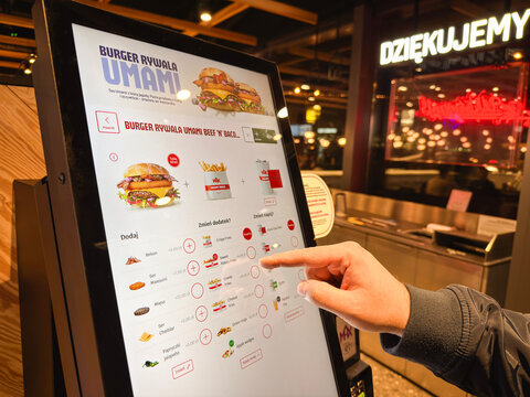 09.12.2024, Jastrzębie-Zdr&oacute;j, Poland: Customer using a Max Burgers self-order kiosk inside a modern fast-food restaurant
