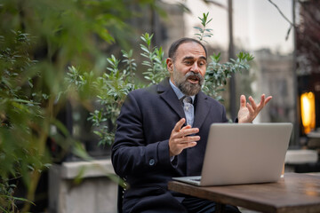 Mature man having video call gesturing with hands