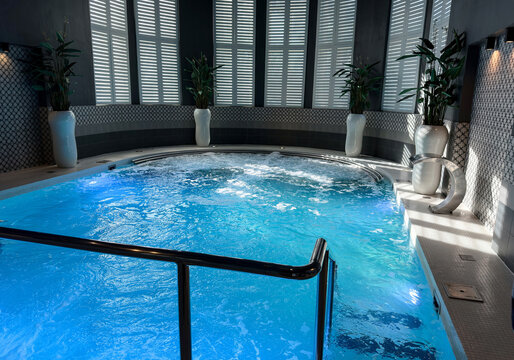 Luxury indoor swimming pool and spa with bubbling blue water