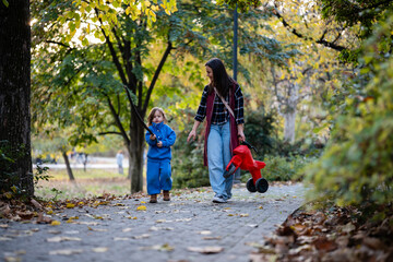 Fototapeta premium Mother and child walking in autumn park