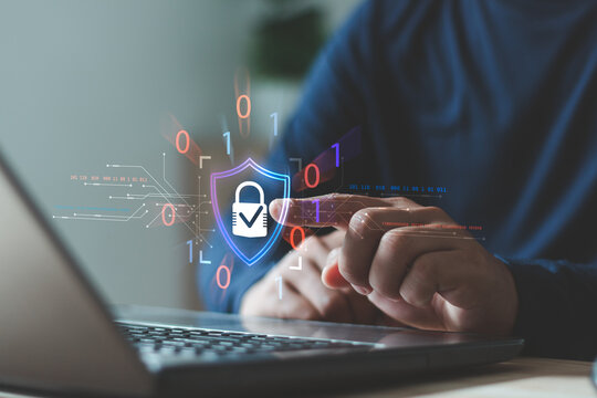 Businessman using laptop and touch digital shield padlock icon, symbolizing cybersecurity innovation, data protection, privacy, secure technology, encryption, compliance and online safety solutions.