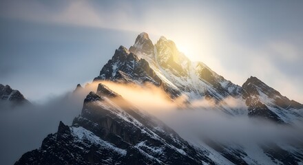 Majestic snow-capped mountain peak illuminated by sunlight with clouds surrounding the summit during daytime