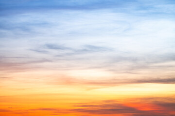 Sunset or sunrise sky with a vibrant gradient of orange, gold, and soft blue. Clear atmosphere with wispy clouds. Peaceful, natural light background. hope, freedom, new day and inspirational Concepts