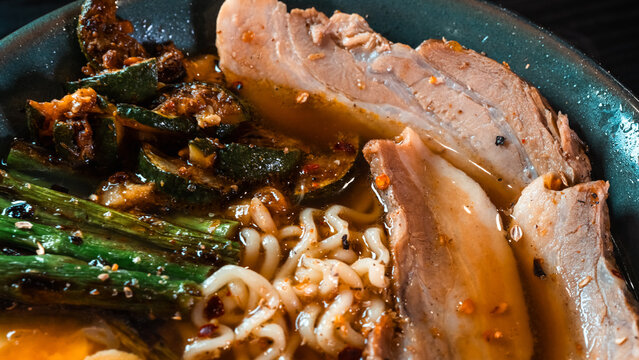 Delicious pork belly ramen with fresh asparagus, zucchini, and Nissin noodles. Rich broth, perfect comfort food. Quick and flavorful meal for Asian cuisine lovers.