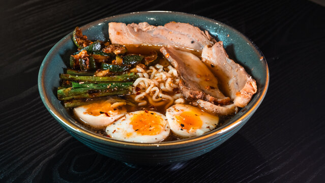 Delicious pork belly ramen with fresh asparagus, zucchini, and Nissin noodles. Rich broth, perfect comfort food. Quick and flavorful meal for Asian cuisine lovers.