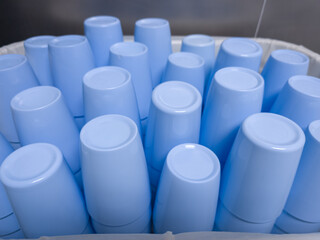 Clean blue plastic cups stacked upside down in a white container for drying. 