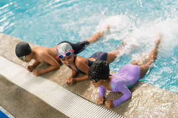 Children learning swimming techniques in poolside lesson