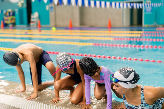 Children learning swimming skills at indoor pool