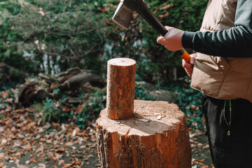 Chopping and preparing firewood.man chops wood on a large stump outside.Heating season. Solid heating fuel.Preparing firewood for the heating season