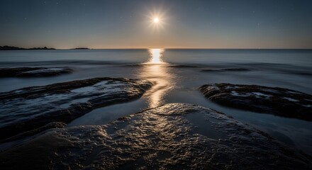 A serene view of the ocean at sunset with the sun reflecting on the water and rocks in the foreground, creating a peaceful and calming scene