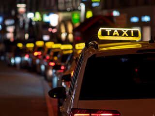 Illuminated Taxi Signs Lining a City Street at Night in Munich Germany