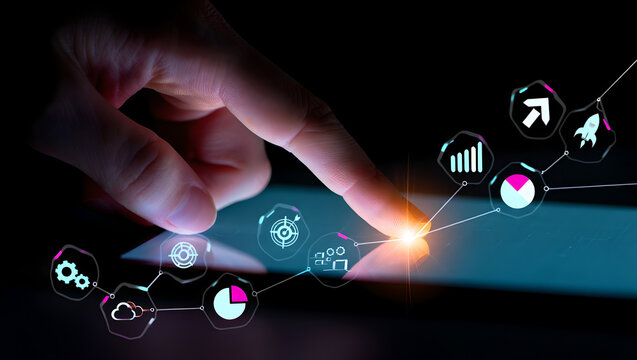 Hand touching a glowing line graph/network on a surface, connecting various business icons.