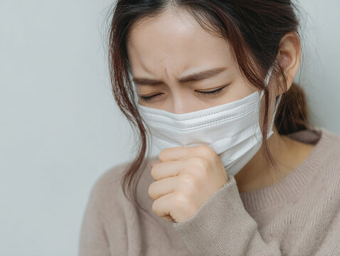 咳をするマスクを着けた体調不良の女性