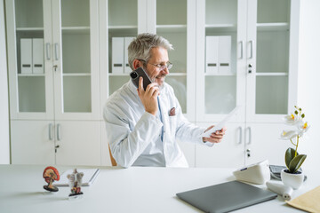 Senior doctor making medicine consultation using mobile phone