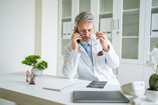 Doctor having serious phone call in medical office