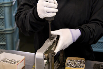 工場で部品のねじを締める職人の手