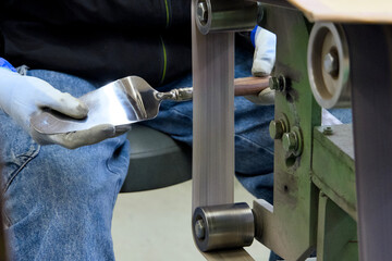 ケーキサーバーを手作業で磨く作業者の手